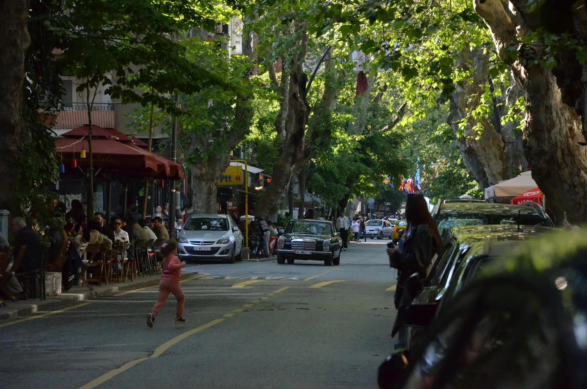 A scenic view of Main Street in Melrose, featuring historic brick buildings and local storefronts under a clear blue sky.